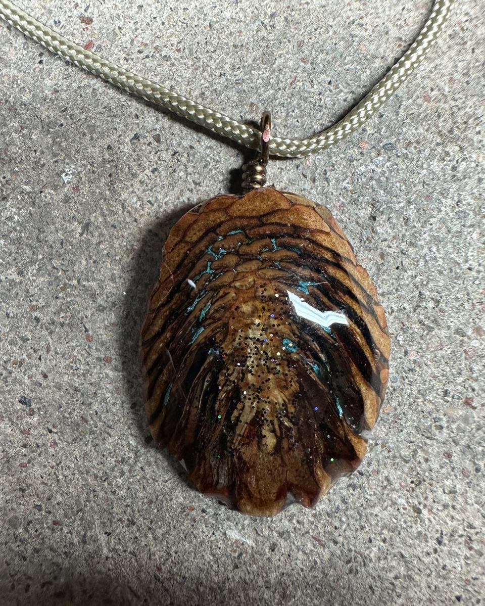 Close view of turquoise veins running between tan scales with black and blue glitter below them
