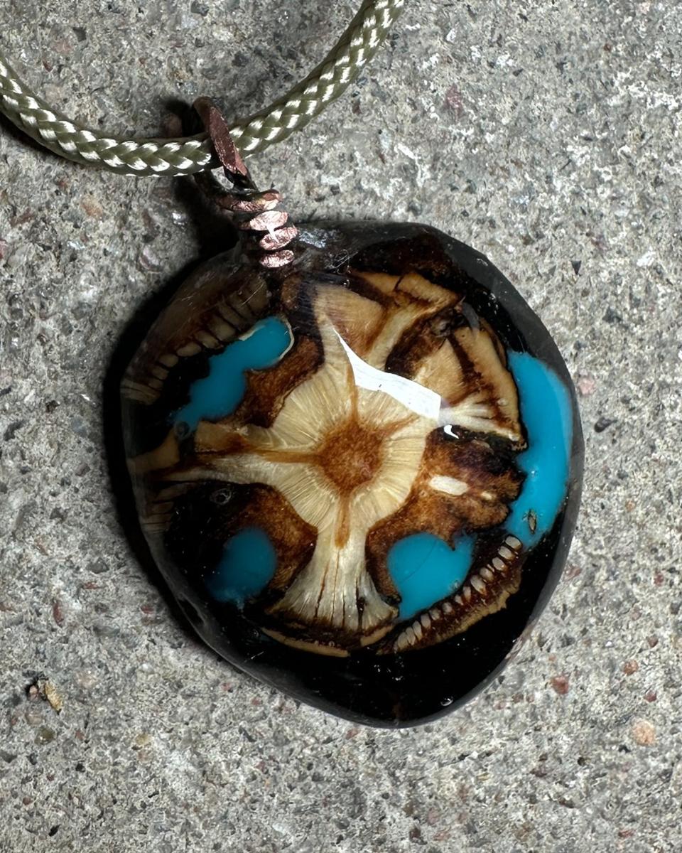 Close view of the cream star core with brown rings, turquoise sitting in the gaps around it